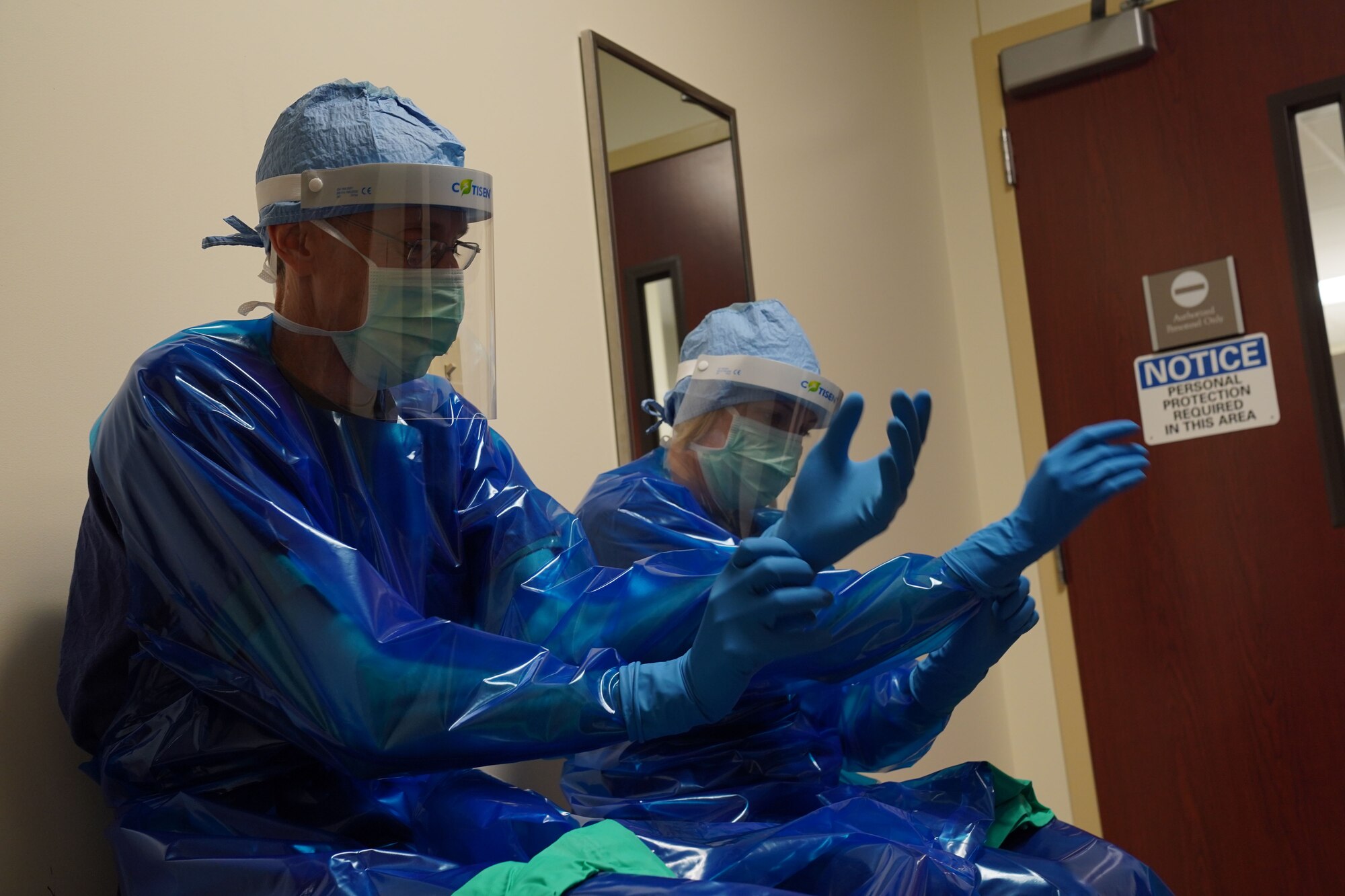 U.S. Air Force Col. Kirsten Aguilar, Joint Base Elmendorf-Richardson and 673d Air Base Wing commander, and U.S. Air Force Chief Master Sgt. Lee Mills, JBER and 673d ABW command chief, don protective gear before participating in the sterilization process for 673d Surgical Operations Squadron’s surgical instruments during a 673d SGCS immersion tour at JBER, Alaska, Sept. 29, 2020. Aguilar familiarized herself with the 673d SGCS and its role in supporting readiness after taking command of the installation July 14, 2020. The 673d SGCS provides a full range of medical care to include surgical and non-surgical intervention to JBER and the greater Anchorage area.