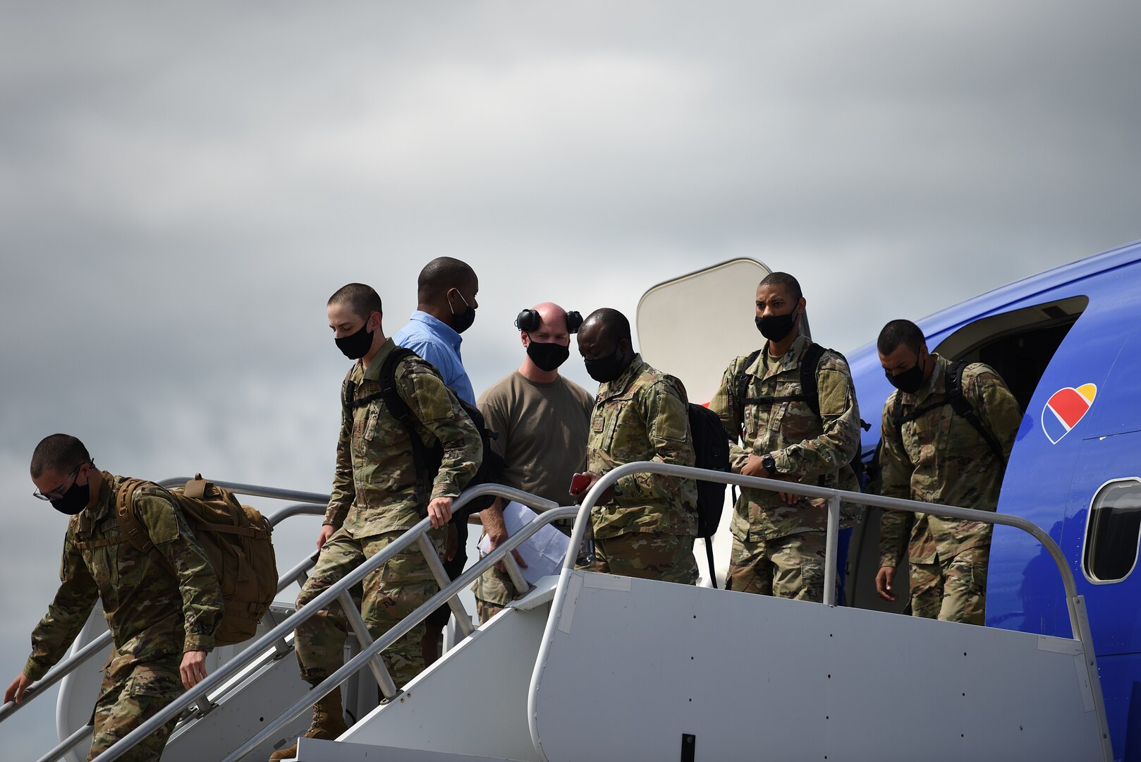 Basic military training graduates from Lackland Air Force Base, Texas, exit a commercial aircraft at Keesler Air Force Base, Mississippi, Sept. 29, 2020. BMT graduates used to be transported by bus from Lackland, but ever since COVID-19, they transitioned to being transported by aircraft to reduce the risk of infection among the students to keep the training pipeline going. (U.S. Air Force photo by Senior Airman Suzie Plotnikov)