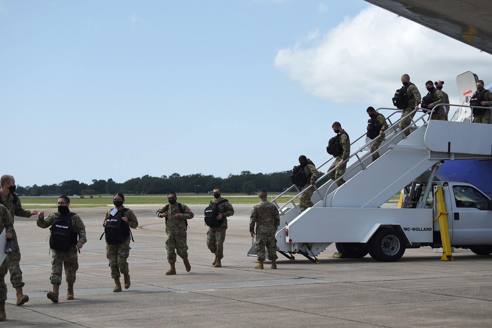 Basic military training graduates from Lackland Air Force Base, Texas, exit a commercial aircraft at Keesler Air Force Base, Mississippi, Sept. 29, 2020. BMT graduates used to be transported by bus from Lackland, but ever since COVID-19, they transitioned to being transported by aircraft to reduce the risk of infection among the students to keep the training pipeline going. (U.S. Air Force photo by Senior Airman Suzie Plotnikov)