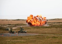 An explosion is seen on a grassy field