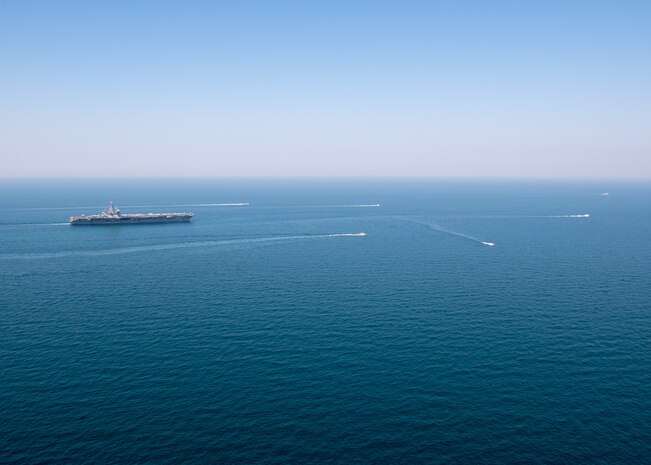 The aircraft carrier USS Nimitz (CVN 68) sails in the Arabian Gulf with Mark VI patrol boats attached to Task Force (TF) 56 and Bahrain Coast Guard ships, Oct. 11. TF 56 and the Nimitz Carrier Strike Group are deployed to the U.S. 5th Fleet area of operations in support of naval operations to ensure maritime stability and security in the Central Region, connecting the Mediterranean and Pacific through the Western Indian Ocean and three critical chokepoints to the free flow of global commerce.