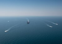 The aircraft carrier USS Nimitz (CVN 68) sails in the Arabian Gulf with Mark VI patrol boats attached to Task Force (TF) 56 and Bahrain Coast Guard ships, Oct. 11. TF 56 and the Nimitz Carrier Strike Group are deployed to the U.S. 5th Fleet area of operations in support of naval operations to ensure maritime stability and security in the Central Region, connecting the Mediterranean and Pacific through the Western Indian Ocean and three critical chokepoints to the free flow of global commerce.