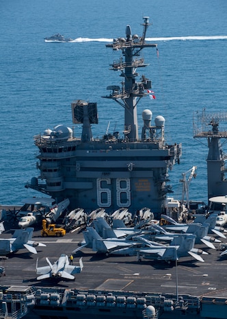 A Mark VI patrol boat attached to Task Force (TF) 56, sails alongside the aircraft carrier USS Nimitz (CVN 68) in the Arabian Gulf, Oct. 11. TF 56 and the Nimitz Carrier Strike Group are deployed to the U.S. 5th Fleet area of operations in support of naval operations to ensure maritime stability and security in the Central Region, connecting the Mediterranean and Pacific through the Western Indian Ocean and three critical chokepoints to the free flow of global commerce.