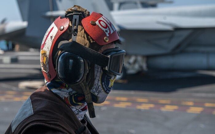 A Sailor prepares to remove chains from a helicopter on the flight deck of the aircraft carrier USS Nimitz (CVN 68) in the Arabian Gulf, Oct. 11. Nimitz is deployed to the U.S. 5th Fleet area of operations in support of naval operations to ensure maritime stability and security in the Central Region, connecting the Mediterranean and Pacific through the Western Indian Ocean and three critical chokepoints to the free flow of global commerce.
