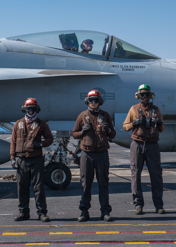 201011-N-KZ419-1631 ARABIAN GULF (Oct. 11, 2020) - Sailors watch as a helicopter attached to Helicopter Sea Combat Squadron (HSC) 26 prepares to takeoff from the flight deck of the aircraft carrier USS Nimitz (CVN 68) in the Arabian Gulf, Oct. 11. HSC-26 and Nimitz are deployed to the   U.S. 5th Fleet area of operations in support of naval operations to ensure maritime stability and security in the Central Region, connecting the Mediterranean and Pacific through the Western Indian Ocean and three critical chokepoints to the free flow of global commerce.