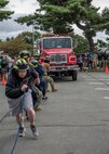 Participants pull a fire truck during the 2020 Fire Muster at Misawa Air Base, Japan, Oct. 6, 2020. The muster is a culmination of fun events designed to bring the community and firefighters together to promote prevention of fire mishaps through education. Fire musters give Airmen from different career fields across the wing an opportunity to test their fitness abilities against one another while experiencing tasks a firefighter would conduct during an emergency. (U.S. Air Force photo by Airman 1st Class China M. Shock)