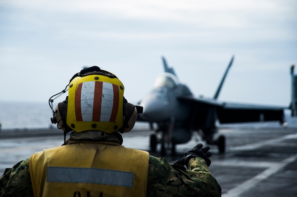 Aviation Boatswain’s Mate (Handling) 1st Class Keyonnia Cook, from Augusta, Georgia, signals to the pilot of an F/A-18E assigned to the “Eagles” of Strike Fighter Squadron (VFA) 115 aboard the aircraft carrier USS Ronald Reagan (CVN 76) while conducting security and stability operations in the South China Sea. Ronald Reagan, the flagship of Carrier Strike Group 5, provides a combat-ready force that protects and defends the U.S. as well as the collective maritime interests of its allies and partners in the Indo-Pacific.