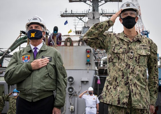 Secretary of the Navy Kenneth J. Braithwaite and Cmdr. Rob Niemeyer, commanding officer of USS Milius (DDG 69) observe morning colors aboard Milius as part of a visit to Commander, Fleet Activities Yokosuka,
