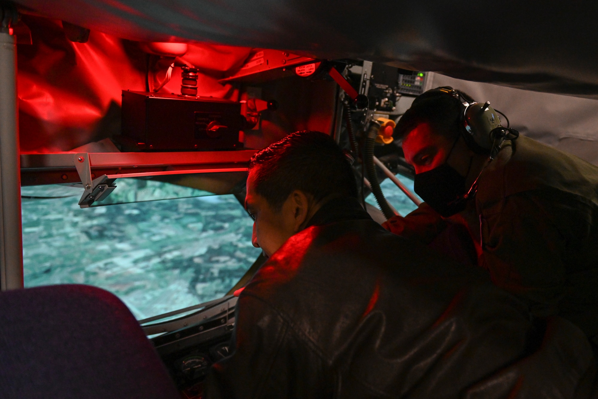 Instructor boom operator show the Wing Commander how to fly the boom in a simulator.