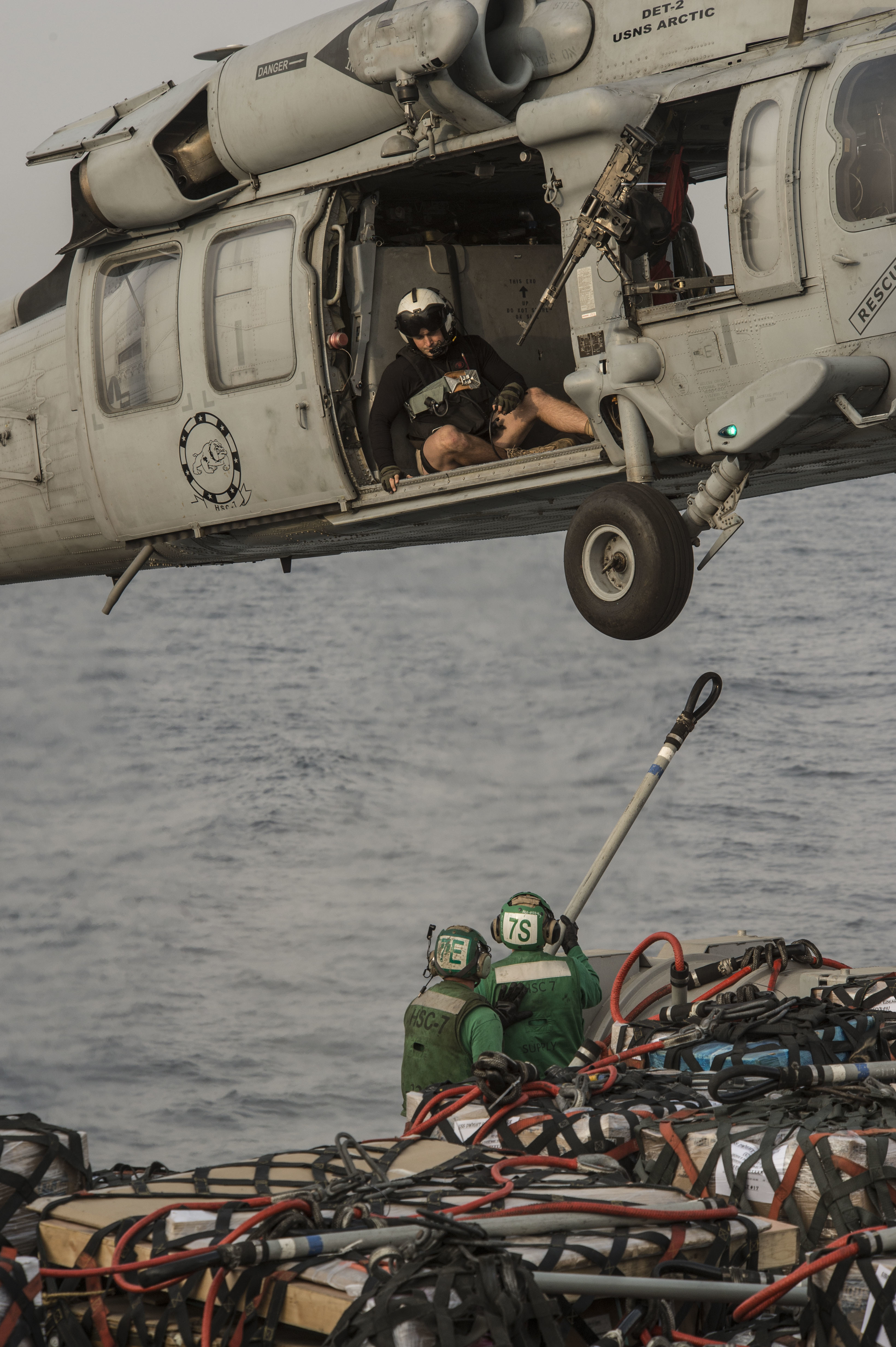 Sailors hook pallets to an MH-60S Sea Hawk helicopter assigned to the Dusty Dogs of Helicopter Sea Combat Squadron (HSC) 7 aboard the fast combat support ship USNS Arctic (T-AOE 8)