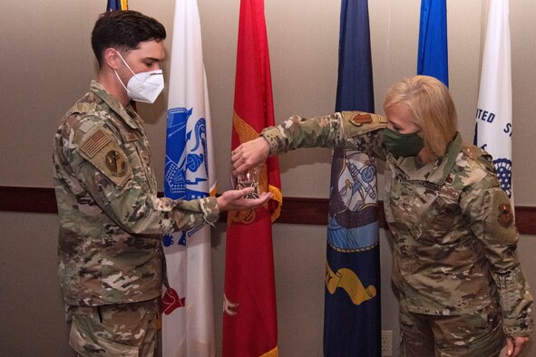 U.S. Air Force Staff Sgt. Levi Freeman, 312th Training Squadron military training leader is coined by Chief Master Sgt. Casy Boomershine, 17th Training Wing command chief, at a 17th Training Wing Standup in the Norma Brown building on Goodfellow Air Force Base, Texas, Oct. 14, 2020. Freeman was recognized as an outstanding Airman during the 17th TRW Spotlight for his exemplary work as an MTL. (U.S. Air Force photo by Airman 1st Class Michael Bowman)