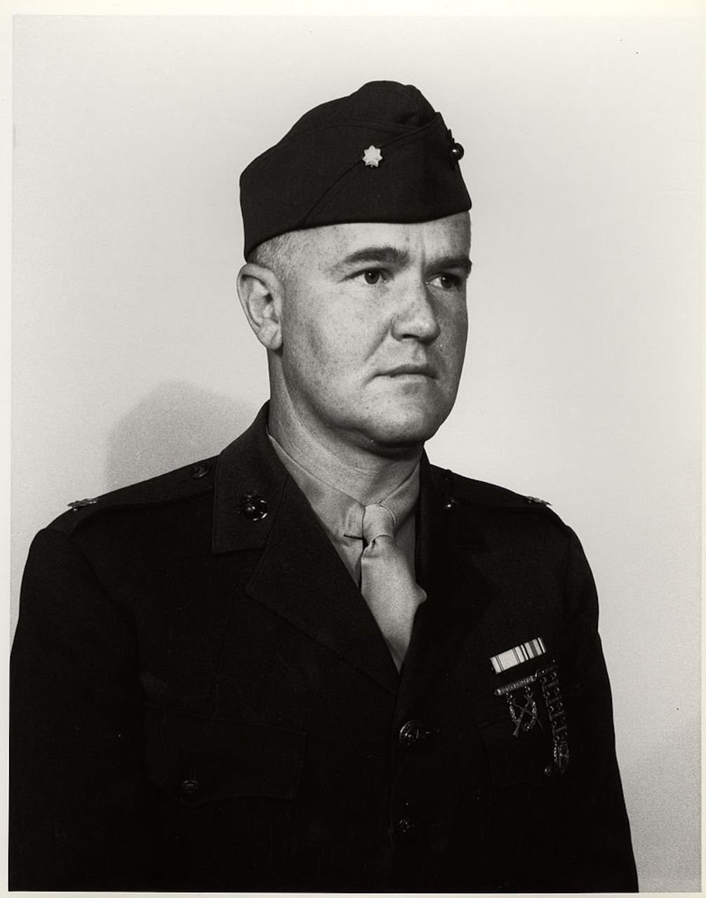 A man in a World War II uniform poses for a photo.