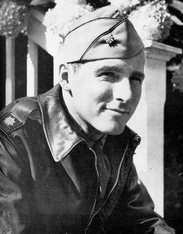 A man in World War II army uniform poses for a photo.