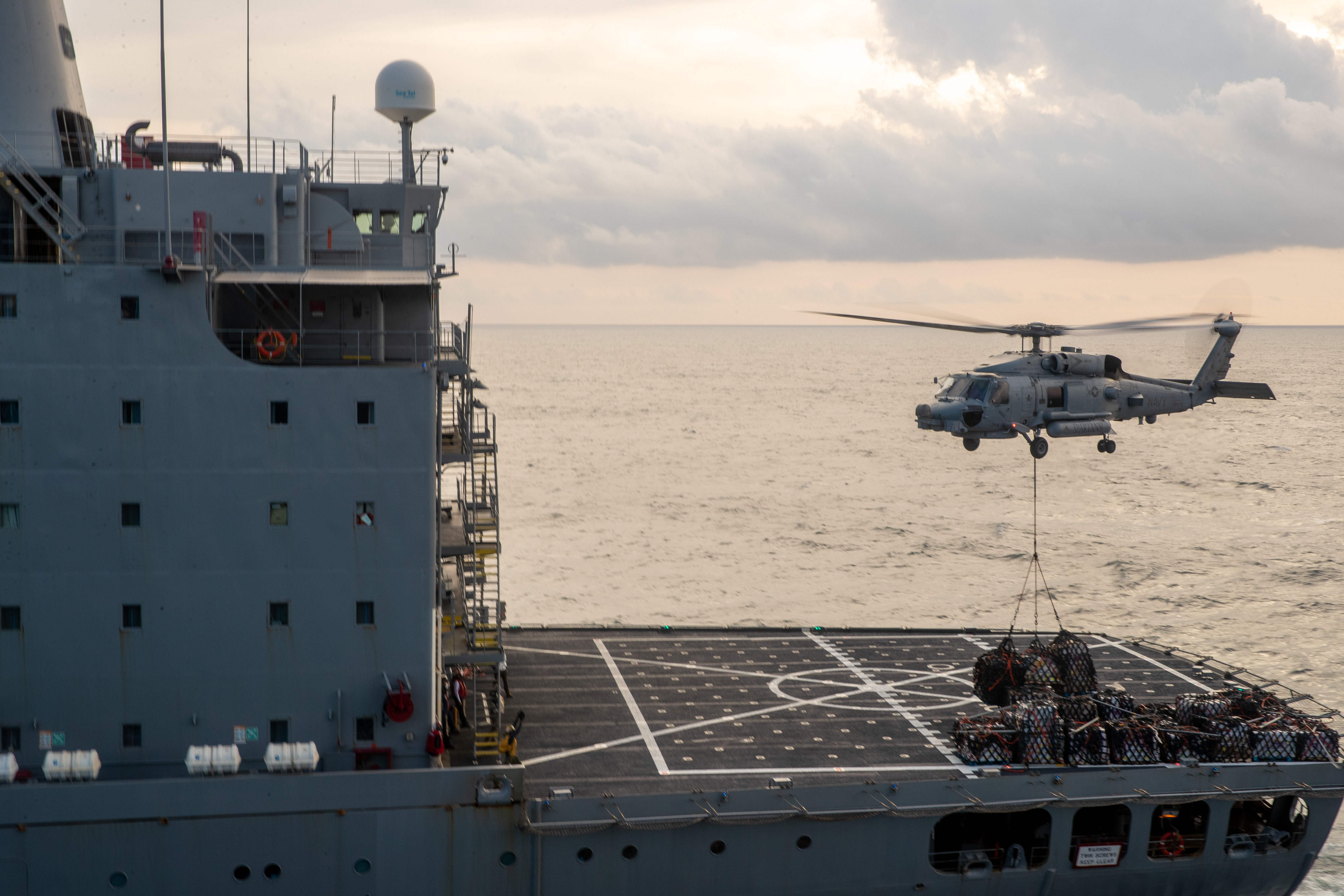 An MH-60R Sea Hawk helicopter, attached to the "Spartans" of Helicopter Maritime Strike Squadron (HSM 70), receives supplies from the Henry J. Kaiser-class fleet replenishment oiler USNS John Lenthall (T-AO 189) during vertical replenishing-at-sea with the aircraft carrier USS Gerald R. Ford (CVN 78) Oct. 2, 2020.