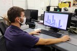 Engineering Technician Adrian Wos reviews 3D models of potential Fiber Optic Sensing System (FOSS) housing units to be 3D printed