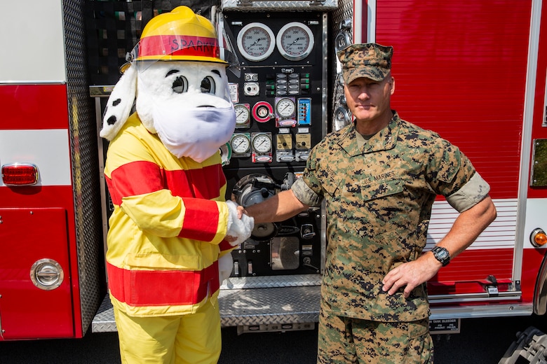 U.S. Marine Corps Maj. Gen. Julian D. Alford, commanding general, Marine Corps Installations East-Marine Corps Base Camp Lejeune, shakes hands with Sparky the fire dog on MCB Camp Lejeune, North Carolina, Oct. 6, 2020. This year’s fire prevention week teaches fire safety, precautions, and awareness while highlighting this year’s theme, "Serve Up Fire Safety in the Kitchen" running from Oct. 4-10. (U.S. Marine Corps photo by Lance Cpl. Christian Ayers)