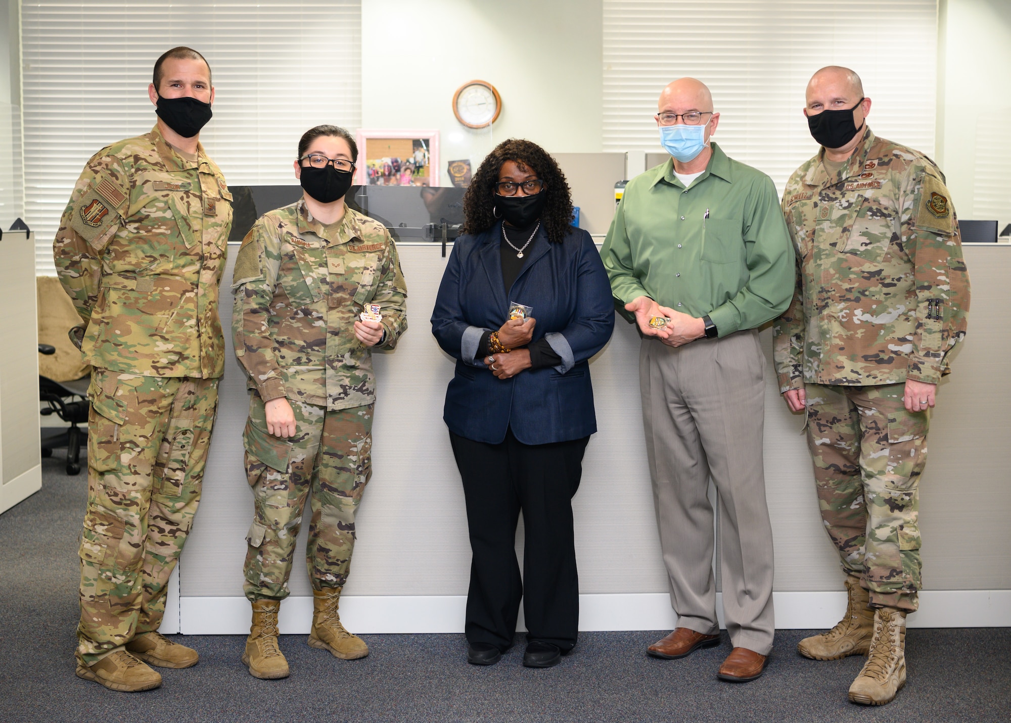Finance team receives coin from vice wing commander and command chief.