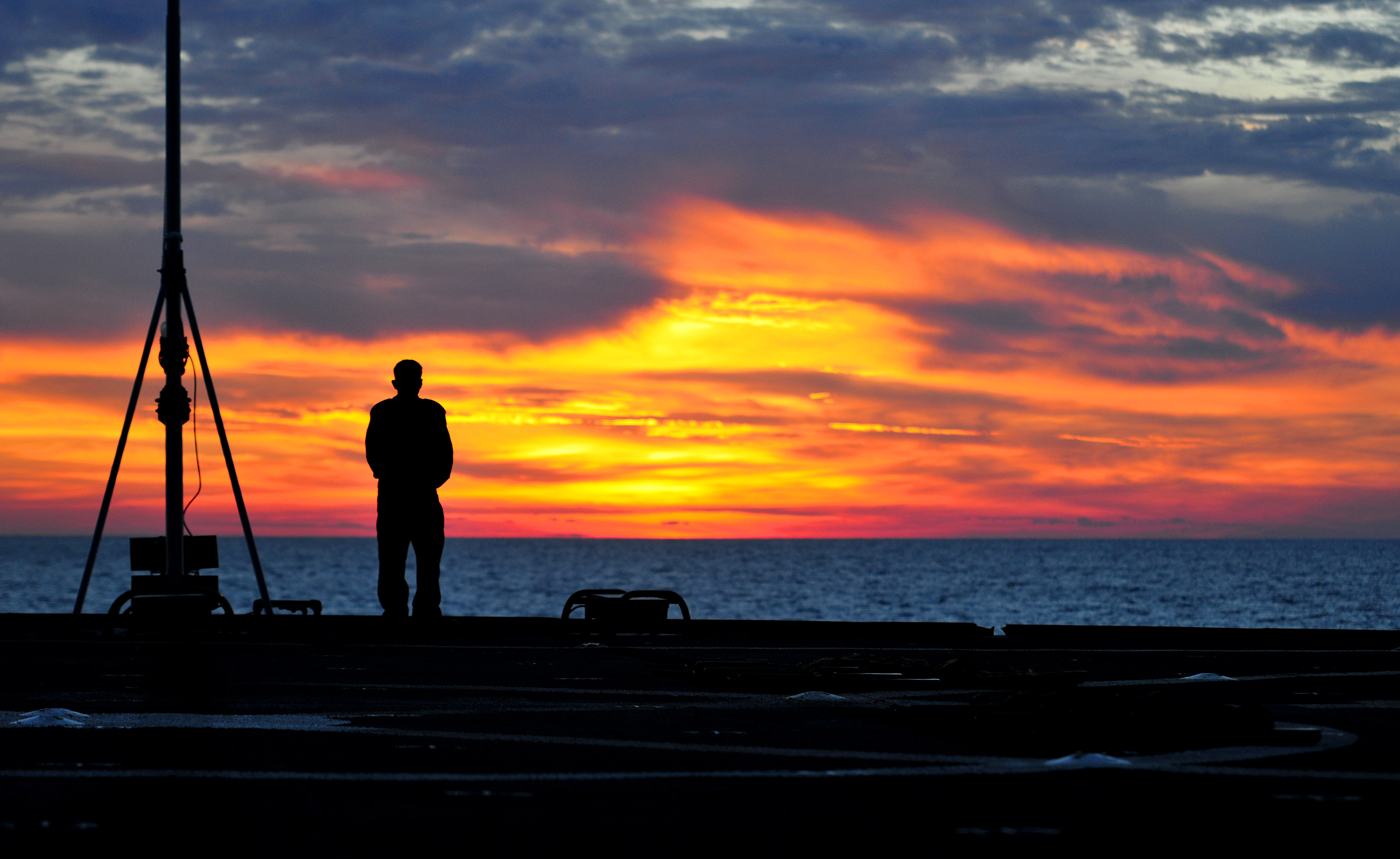 Chief Machinist's Mate Jonathan Sarmiento, a Sailor aboard the amphibious command ship USS Mount Whitney (LCC 20), looks out over the sea prior to a low-light weapons qualification course while underway