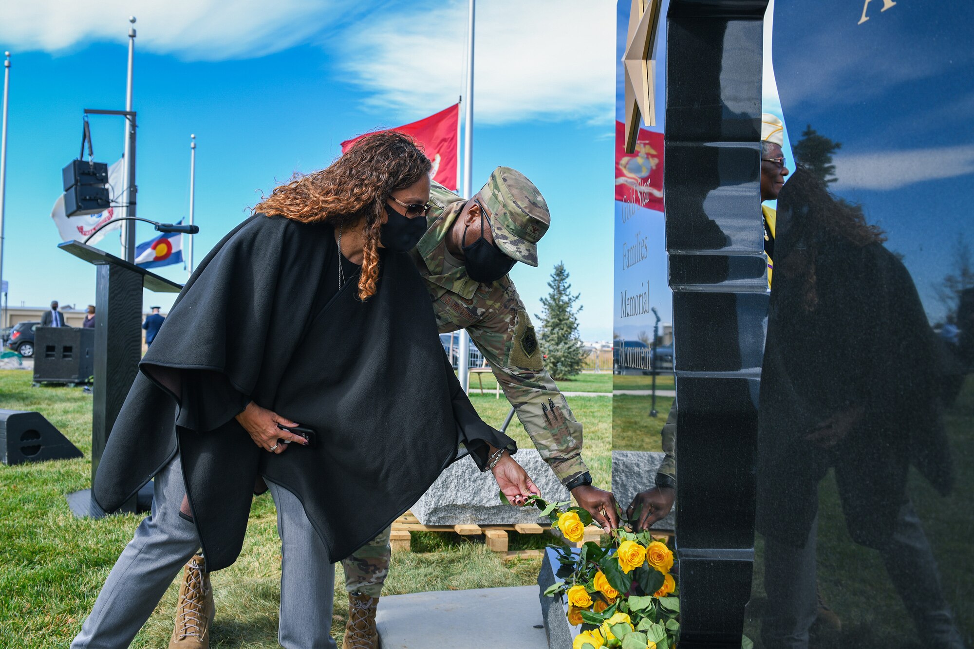 Colonel Devin Pepper, Buckley Garrison commander, and Alicia Pepper, a military spouse, both place yellow flowers onto the Gold Star Families Memorial Monument Oct. 14, 2020, at the Colorado Freedom Memorial in Aurora, Colo.