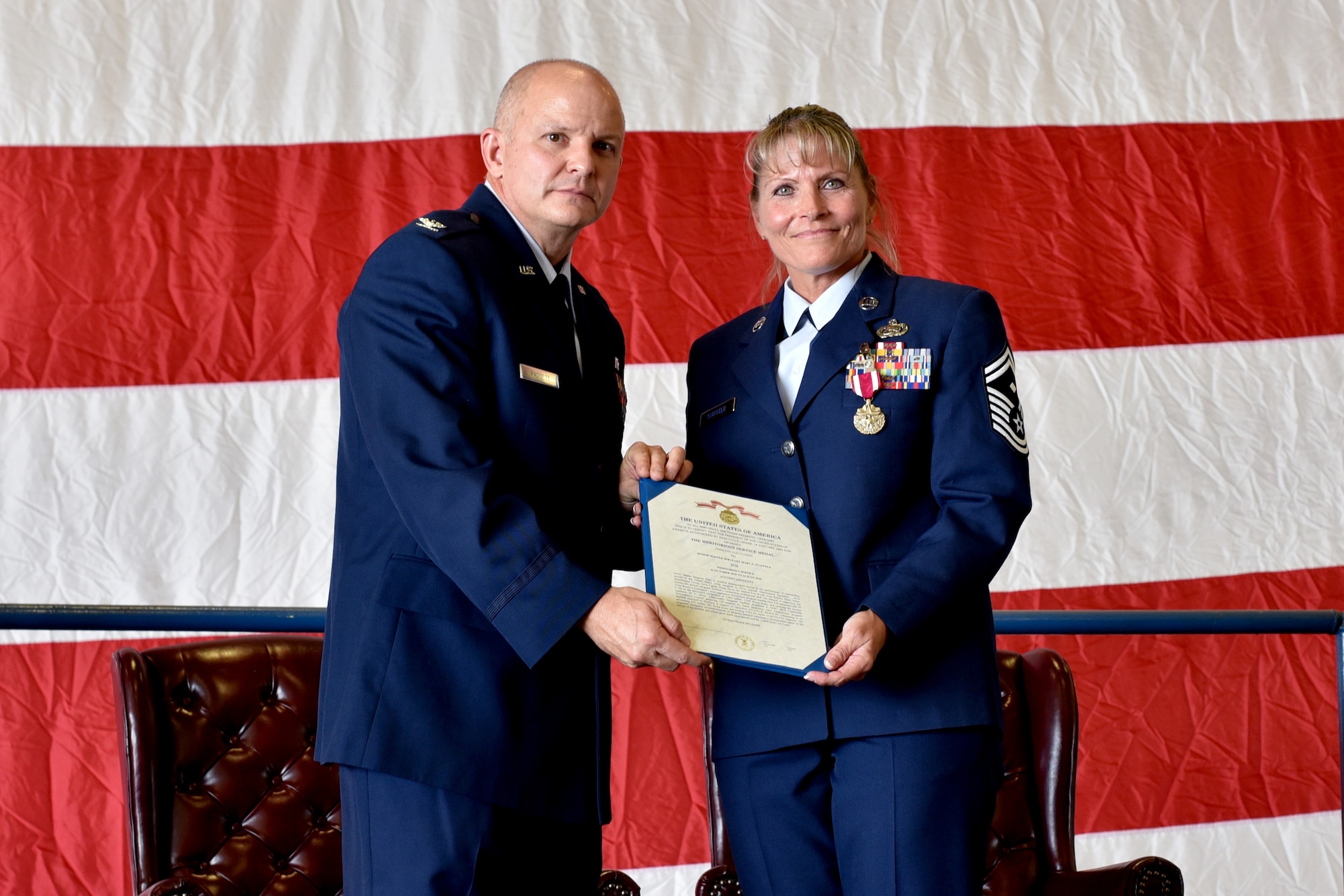 Col. Joshua Padgett, 301st Fighter Wing Operations Group commander presents Senior Master Sgt. Mary Staffeld, 301st Fighter Wing Aircraft Maintenance Squadron first sergeant, with a Meritorious Service Medal prior to her retirement at U.S. Naval Air Station Joint Reserve Base Fort Worth, Texas on October 3, 2020. Of her 22 years of service, Staffeld spent 15 years at the wing and played a vital role as a first sergeant. (U.S. Air Force photo by Staff Sgt. Randall Moose)