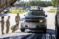 U.S. Navy Information System Technician 1st Class Albert Givens, assigned to Joint Task Force Civil Support (JTF-CS), pulls a fleet vehicle into a C-17 Globemaster III trainer at Fort Lee, Va. during load training as part of Exercise KODA.