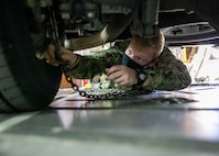 U.S. Navy Hospital Corpsman 3rd Class Tyler Arentzen, assigned to Joint Task Force Civil Support (JTF-CS), ties down a fleet vehicle inside a C-17 Globemaster III trainer at Fort Lee, Va. during load training as part of Exercise KODA.