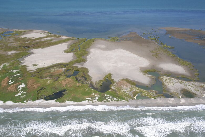 The state of Louisiana constructed two sand berms between 2010 and 2011 to protect the Chandeleur Islands as part of an emergency response plan to mitigate the effects of the Deepwater Horizon oil spill. Most of the sediment placed in the berms mimicked nearshore beneficial use of dredged material applications that are used for barrier island nourishment and restoration. A study found that sediment was transported onto existing island features or across the island into Chandeleur Sound. The build up and reinforcement of the island ensures its viability as wildlife habitat, making this an excellent example of working with natural processes to produce beneficial results. The effort to create the berms and evaluate them was a collaboration between multiple state and federal agencies, including the U.S. Army Corps of Engineers. (U.S. Geological Survey photo by Karen Morgan)