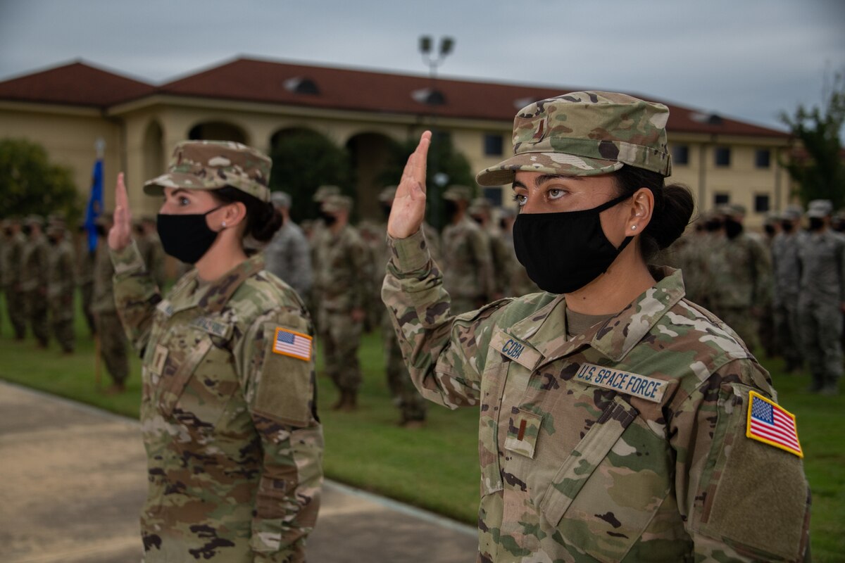 Space Force Second Lieutenants Amy Coba and Elizabeth Kowal, Officer Training School Class 20-08 graduates, raise their right hand and recite the Space Force Oath of Office