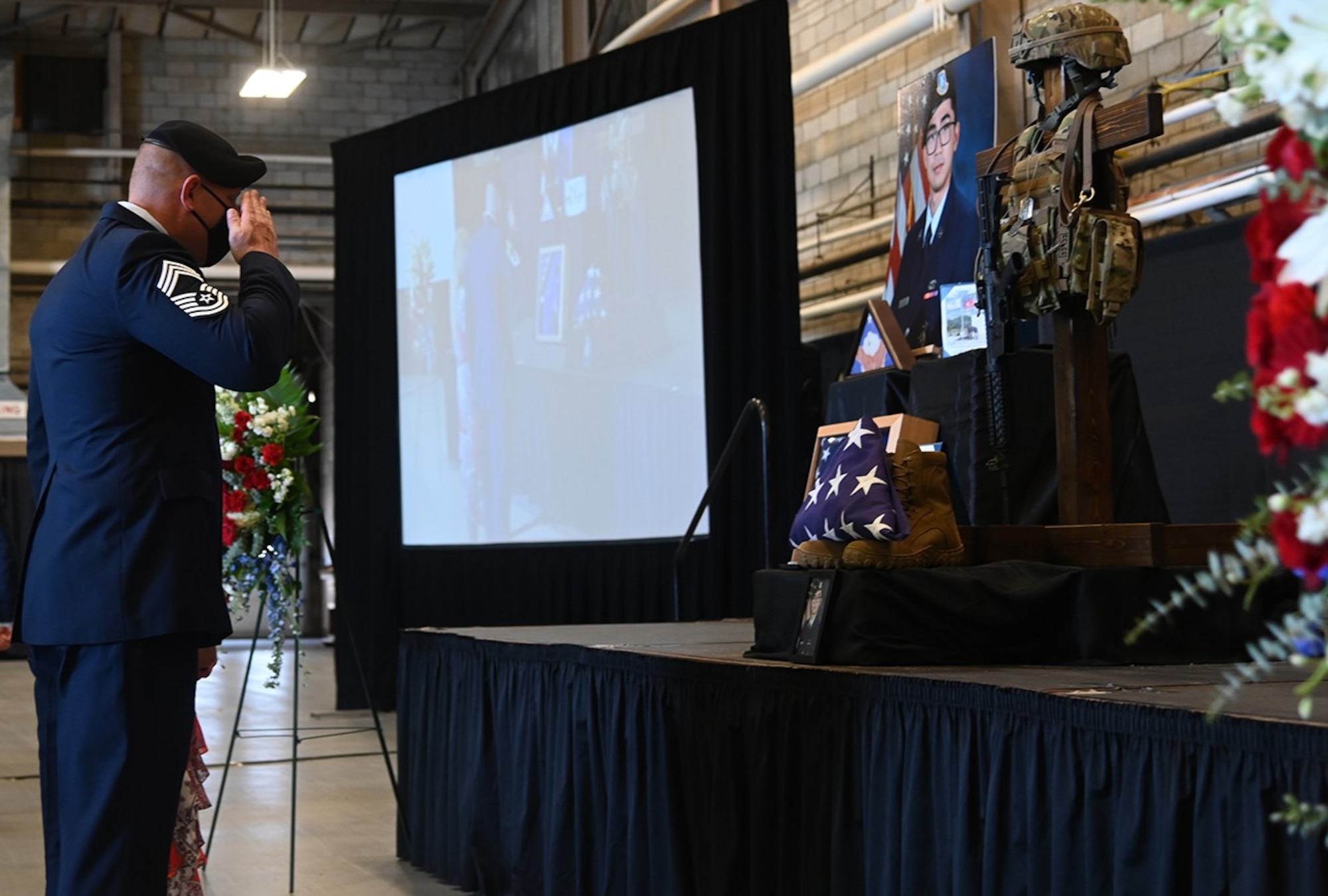 Chief Master Sgt. Justin Geers, 66th Security Forces Squadron manager, salutes a folded flag at the base during a memorial ceremony for Senior Airman Jason “Khai” Phan at Hanscom Air Force Base, Mass., Oct. 16. The service was hosted to commemorate the life and service of Phan, who died in a non-combat related accident while serving overseas Sept. 12. (U.S. Air Force photo by Linda LaBonte Britt)