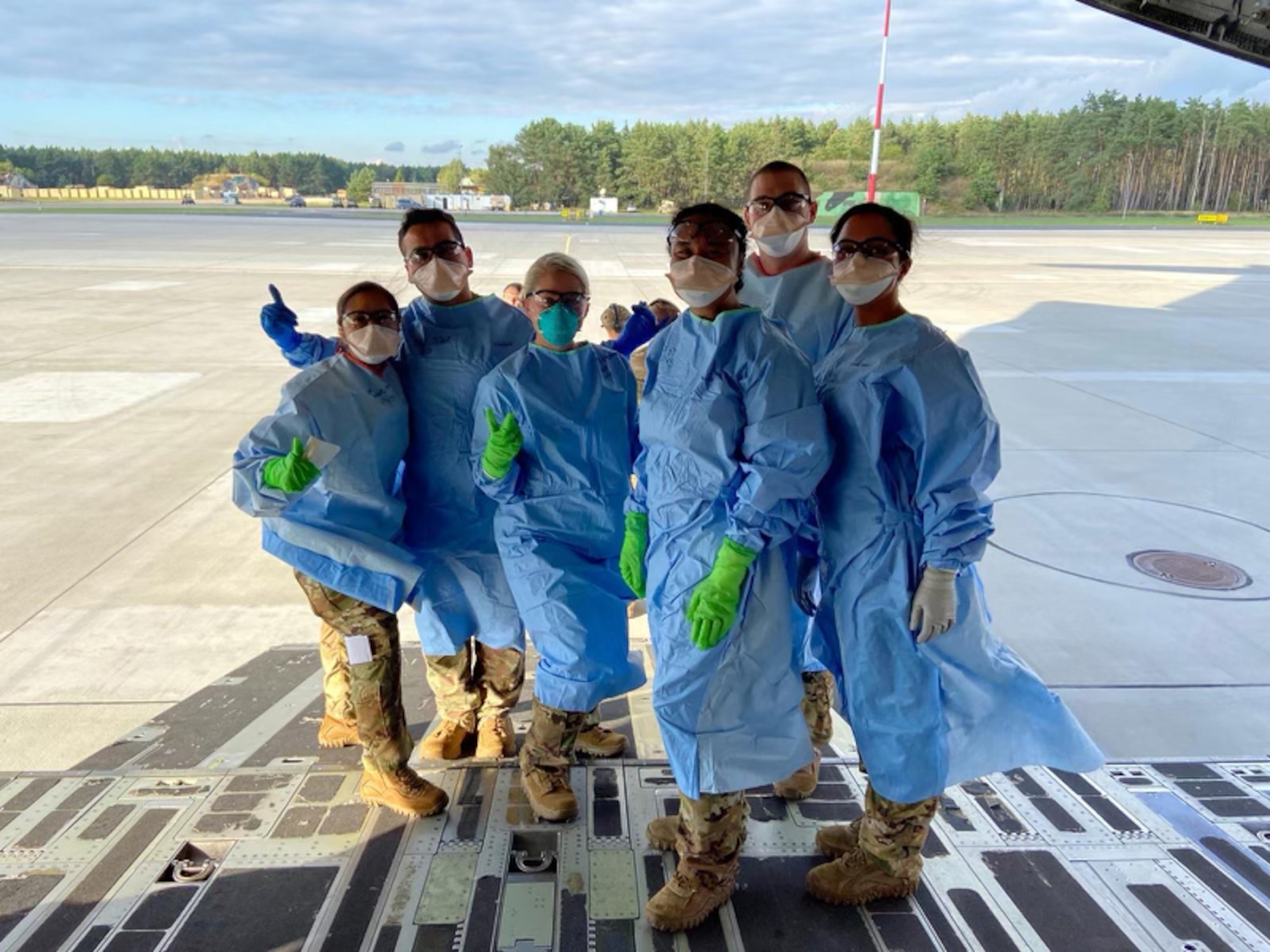 Capt. Alyssa Sandquist (far left), flight nurse for the 36th Aeromedical Evacuation Squadron at Keesler Air Force Base, gives a thumbs up as she and her fellow crew members prepare to work alongside COVID-19 patients on a C-17 Globemaster. From April to September 2020, Sandquist was a part of the 10th Expeditionary Aeromedical Evacuation Flight at Ramstein Air Base, Germany where she helped transport COVID-19 positive individuals to proper care facilities. (Courtesy Photo)