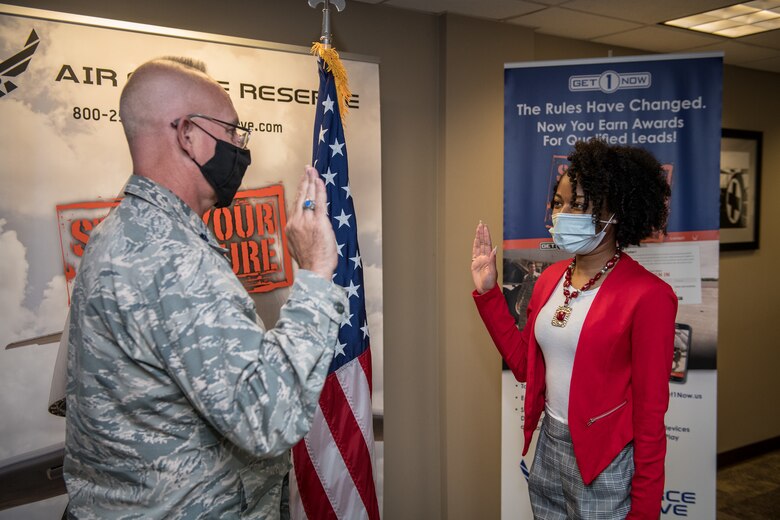 Dominique Burrell recites the oath of enlistment given to her on Oct. 2 2020 by Lt. Col. Stan Paregien, 932nd Airlift Wing Public Affairs Officer, during an enlistment ceremony at the 932nd AW Headquarters building, Scott Air Force Base, Illinois. Burrell will continue her family’s military legacy. “I will become part of a bigger family,” said Burrell “I hope to someday become an officer and look forward to what the Air Force has to provide [me], such as resiliency.”  (U.S. Air Force photo by Christopher Parr)
