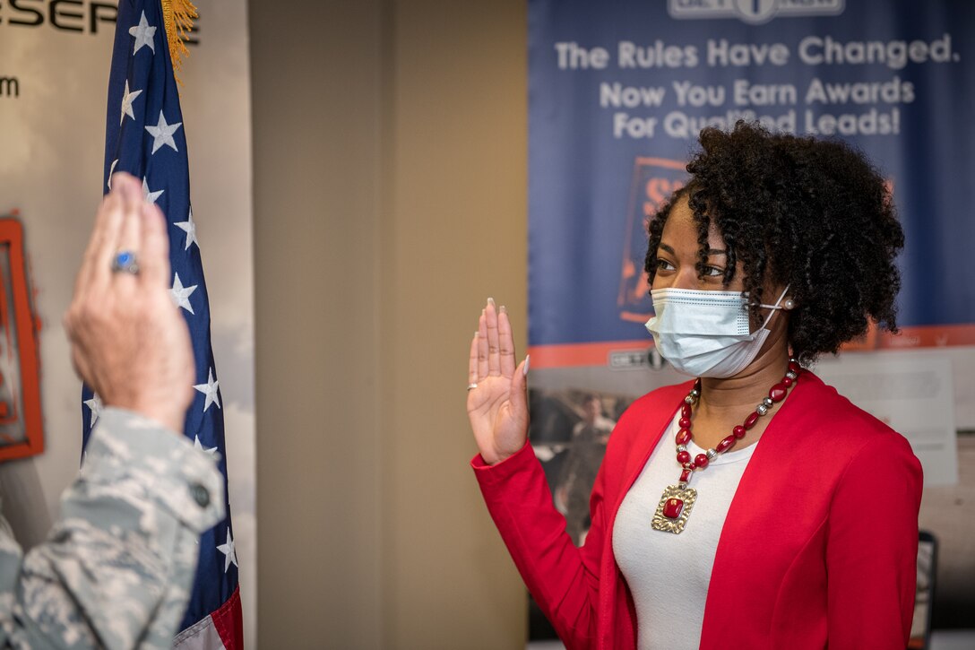 Dominique Burrell recites the oath of enlistment given to her on Oct. 2 2020 by Lt. Col. Stan Paregien, 932nd Airlift Wing Public Affairs Officer, during an enlistment ceremony at the 932nd AW Headquarters building, Scott Air Force Base, Illinois. Burrell will continue her family’s military legacy. “I will become part of a bigger family,” said Burrell “I hope to someday become an officer and look forward to what the Air Force has to provide [me], such as resiliency.”  (U.S. Air Force photo by Christopher Parr)