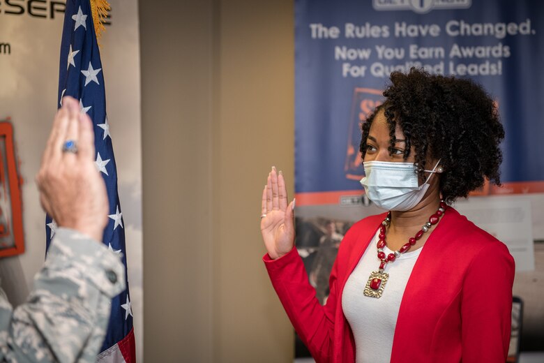 Dominique Burrell recites the oath of enlistment given to her on Oct. 2 2020 by Lt. Col. Stan Paregien, 932nd Airlift Wing Public Affairs Officer, during an enlistment ceremony at the 932nd AW Headquarters building, Scott Air Force Base, Illinois. Burrell will continue her family’s military legacy. “I will become part of a bigger family,” said Burrell “I hope to someday become an officer and look forward to what the Air Force has to provide [me], such as resiliency.”  (U.S. Air Force photo by Christopher Parr)