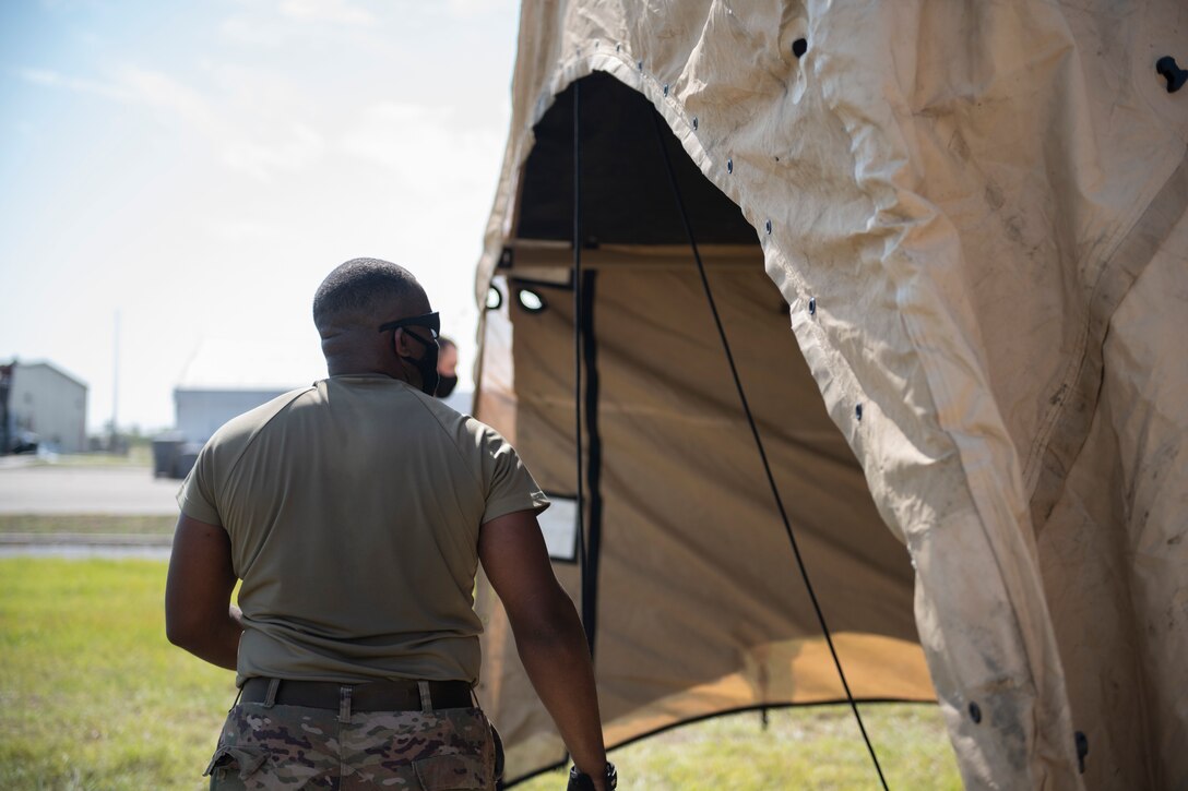 man inspects a tent