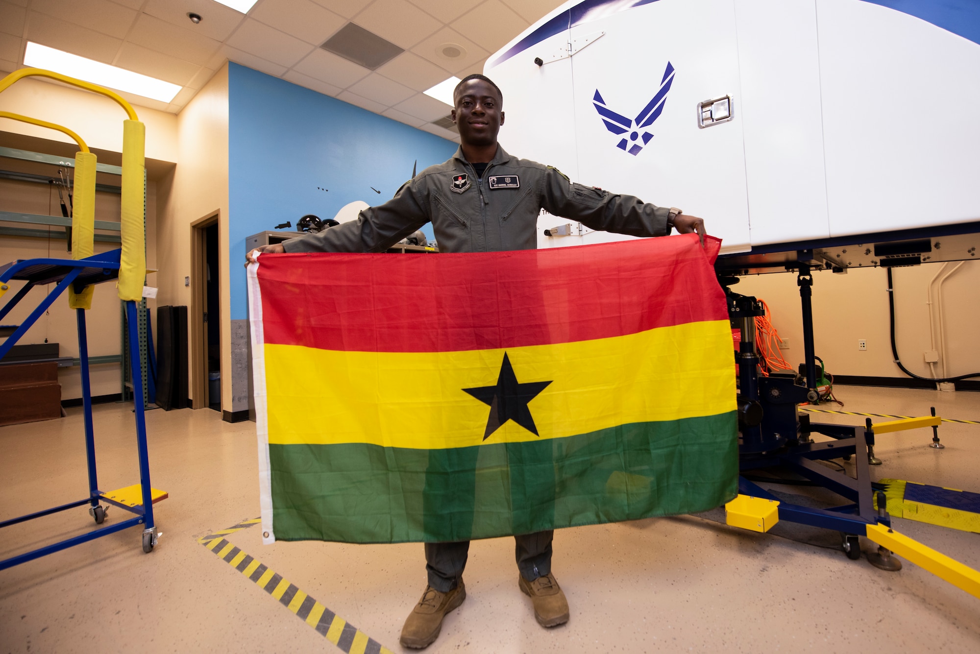 Airman 1st Class Gaddiel Acquaah, a 47th Operations Support Squadron aerospace physiology technician, holds a Ghanaian flag at Laughlin Air Force Base, Texas, Oct. 2, 2020. Acquaah recently received his U.S. citizenship through serving in the U.S. Air Force. Acquaah trains aircrews on everything from handling extreme G-force to egress training. (U.S. Air Force photo by Senior Airman Marco A. Gomez)
