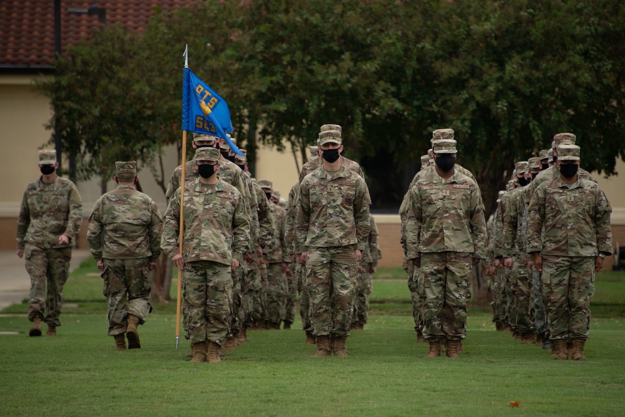 Trainees from Officer Training School Class 20-08 stand at attention during their graduation ceremony