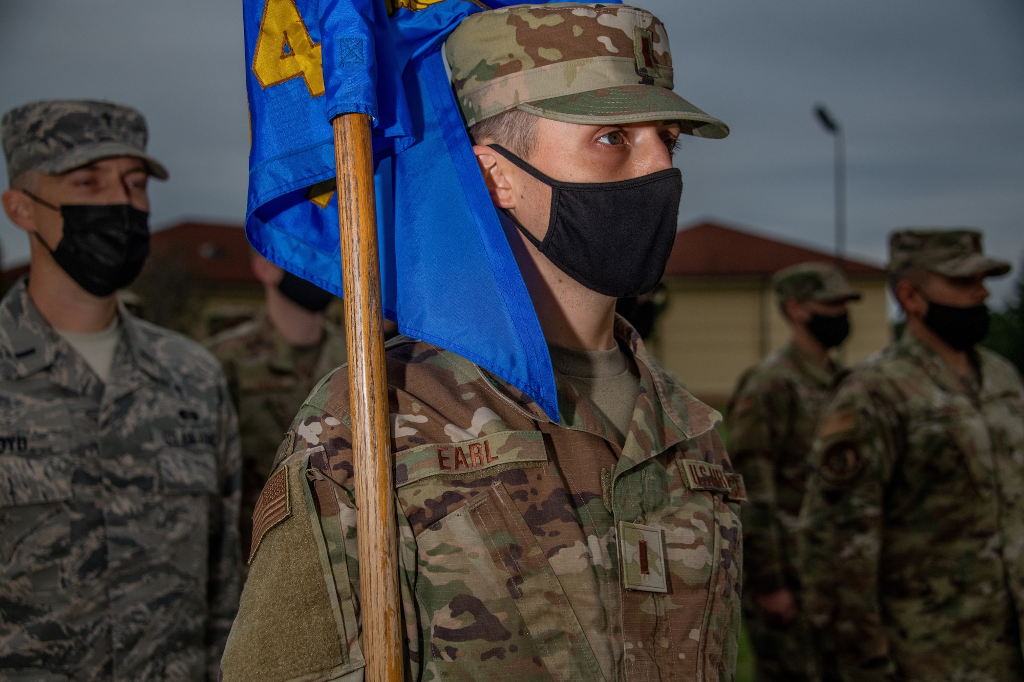 A guidon bearer from Officer Training School Class 20-08 stands at attention during the opening remarks at the OTS parade field