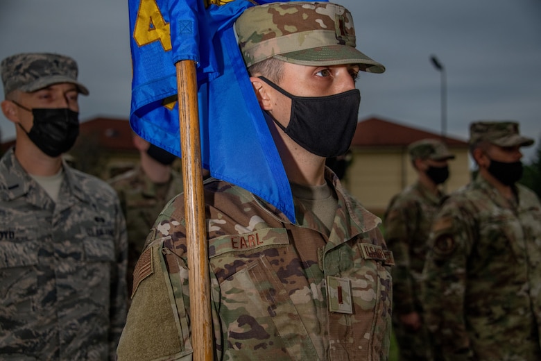 A guidon bearer from Officer Training School Class 20-08 stands at attention during the opening remarks at the OTS parade field