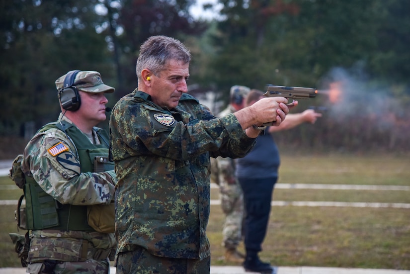 Bulgarian Chief of Defense Adm. Emil Eftimov fires the M-17 handgun, Oct. 8, at a small-arms pop-up range at Volunteer Training Site - Tullahoma. After signing a new training roadmap with the U.S., Bulgarian officials visited the Tennessee National Guard, renewing their partnership through 2030.