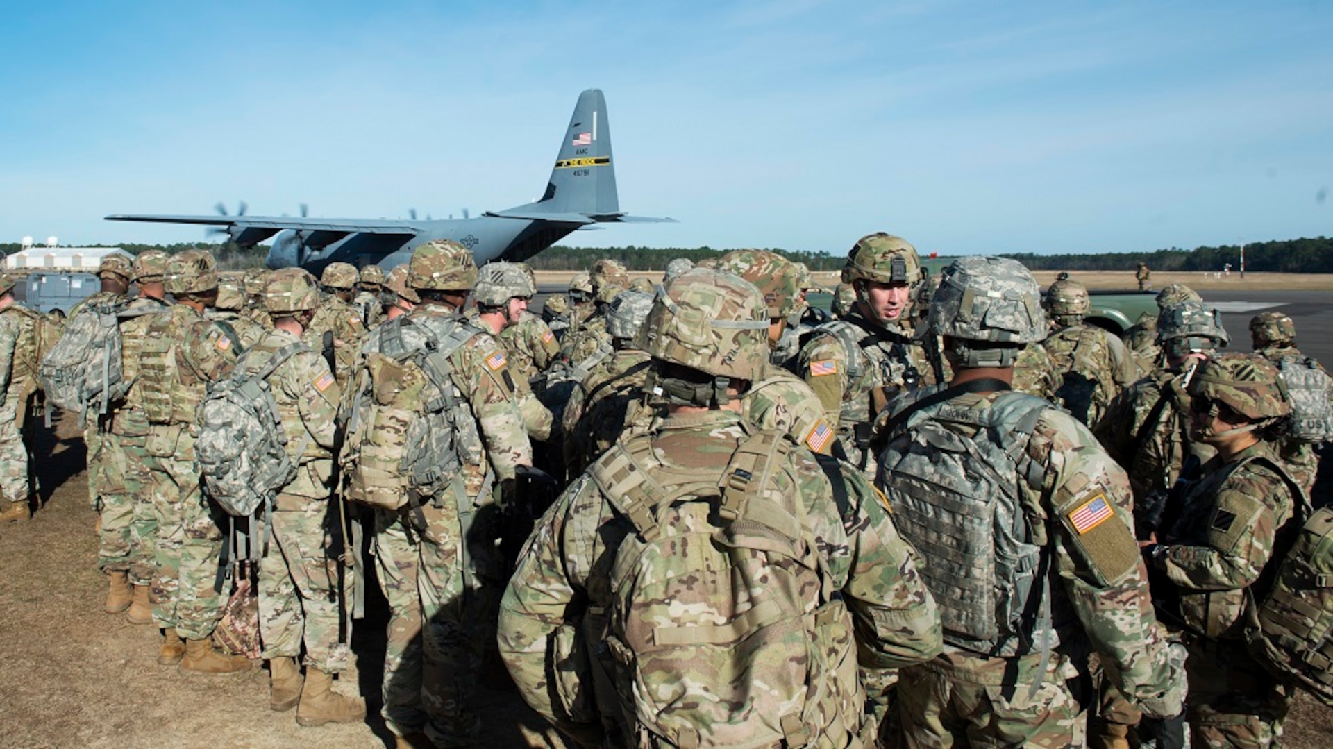 Military members line up for transportation to an exercise location.