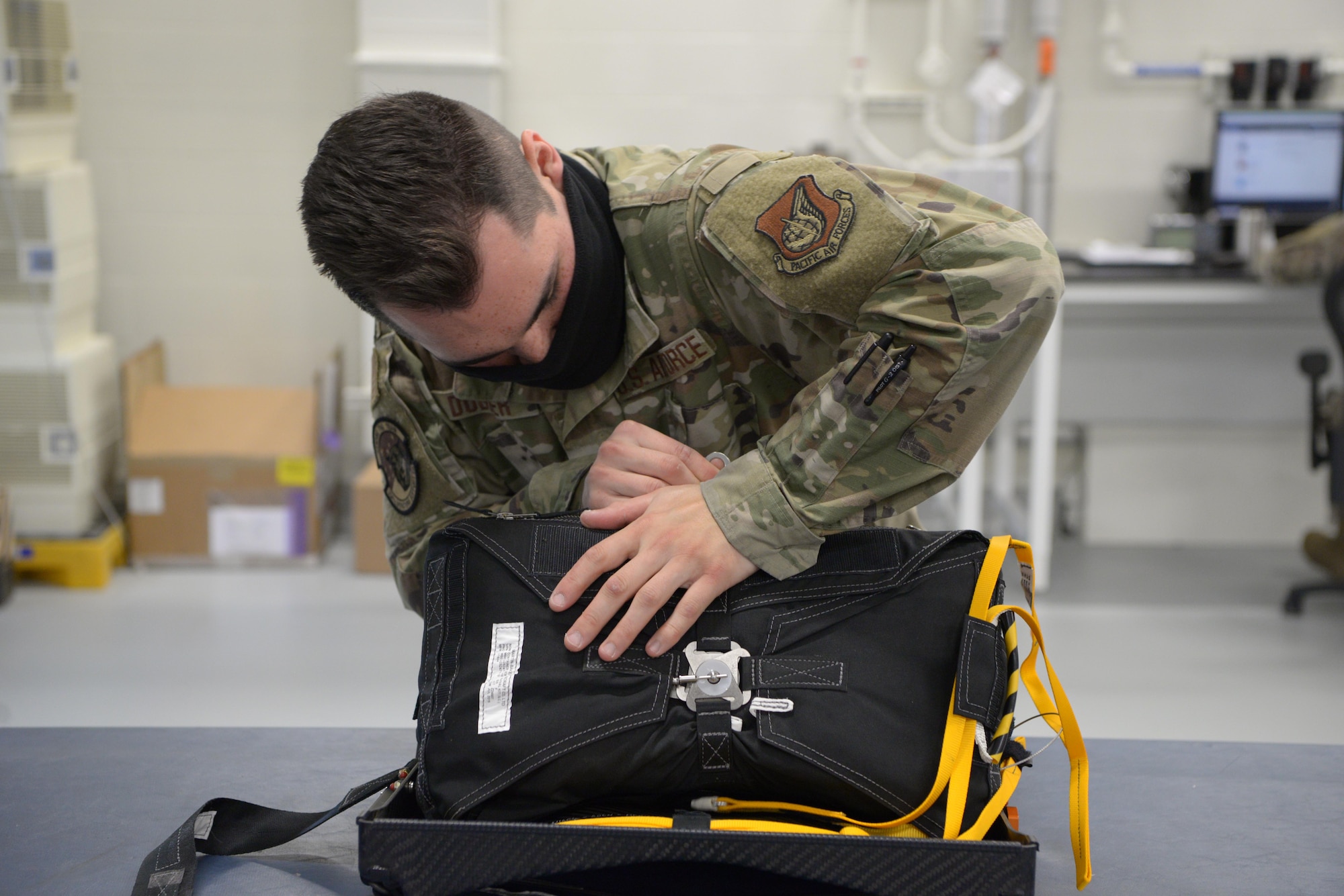 U.S. Air Force Staff Sgt. Ross Dugger, a 354th Operations Support Squadron Aircrew Flight Equipment craftsman, zips up the new arctic survival seat kit for the F-35A Lighting II on Eielson Air Force Base, Alaska, Sept. 25, 2020.