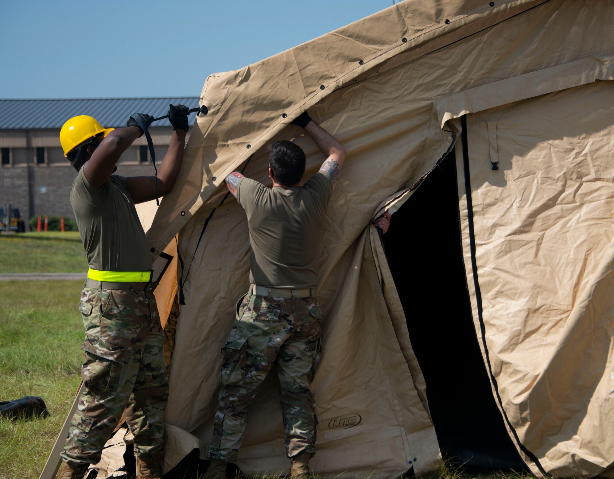 men assemble a tent
