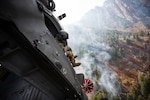 Crew members of the 211th Aviation Regiment conduct air support over the Neffs Canyon fire from a UH-60 Black Hawk helicopter in Salt Lake City, Utah, Sept. 20, 2020. The Black Hawk can drop 600 gallons of water over a wildfire at a time.