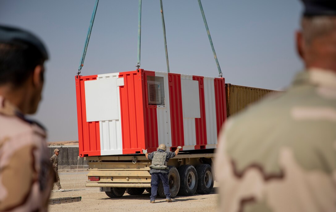 U.S. and Iraqi forces gather for the divestment of equipment from the U.S. government to the government of Iraq at a transfer point near Al Asad Air Base, Iraq, Oct. 15, 2020. Iraqi Maj. Gen. Saadoom Fouad, Q-West Air Base commander, received several containers consisting of air traffic control equipment that will build the Iraqi air force's capability to continue the fight to defeat the Islamic State of Iraq and Syria.(U.S. Army Reserve photo by Spc. Jorge Reyes)