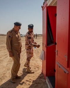 U.S. and Iraqi forces gather for the divestment of equipment from the U.S. government to the government of Iraq at a transfer point near Al Asad Air Base, Iraq, Oct. 15, 2020. Iraqi Maj. Gen. Saadoom Fouad, Q-West Air Base commander, received several containers consisting of air traffic control equipment that will build the Iraqi air force's capability to continue the fight to defeat the Islamic State of Iraq and Syria.(U.S. Army Reserve photo by Spc. Jorge Reyes)