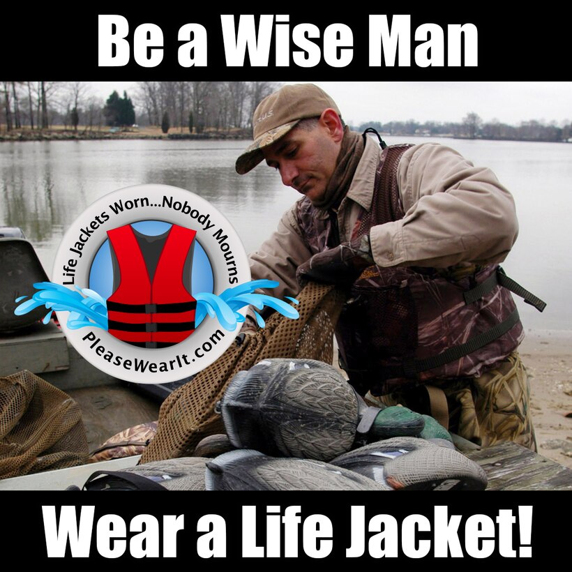Duck Hunter wearing a life jacket as he prepares his decoys for hunting