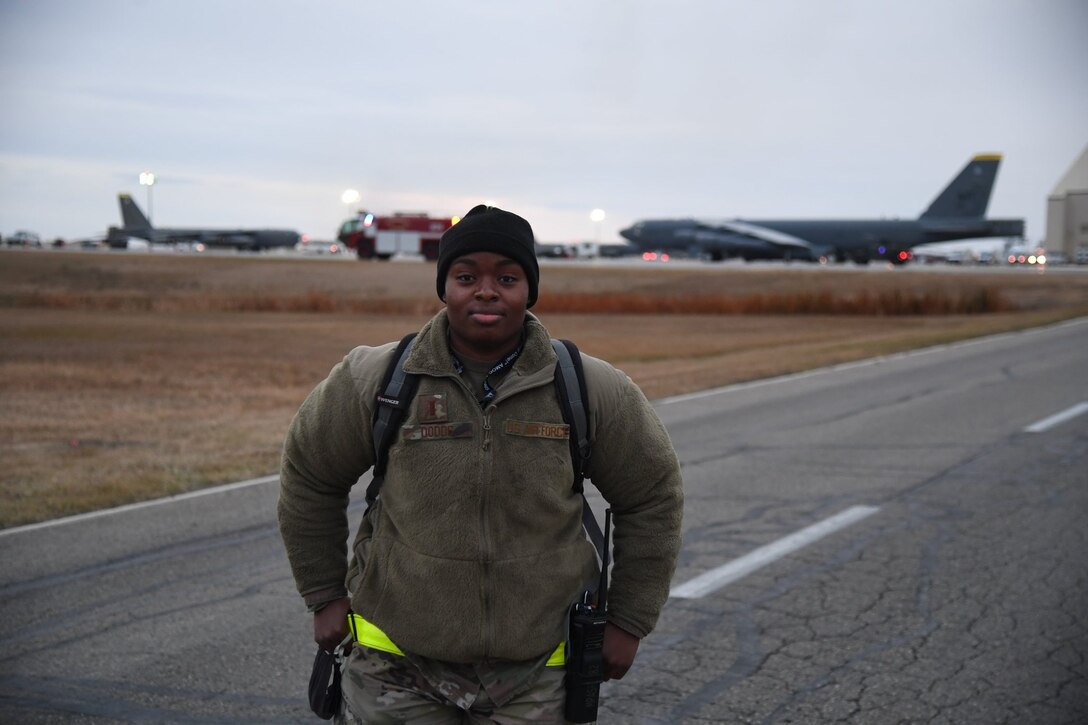 2nd Lt Dodds stands on the flightline in front of a backdrop of B-52s