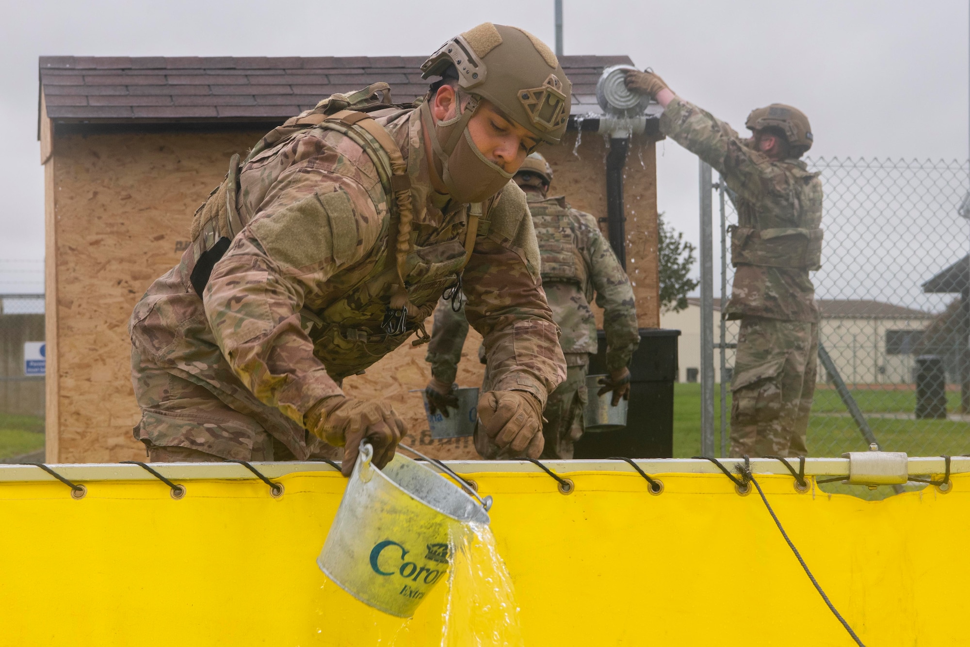U.S. Air Force Senior Airman Luis Maytorena, 100th Security Forces Squadron response force leader, fills a bucket of water during the fire muster competition at Royal Air Force Mildenhall, England, Oct. 14, 2020. The fire muster was held to raise prevention awareness. (U.S. Air Force photo by Airman 1st Class Joseph Barron)