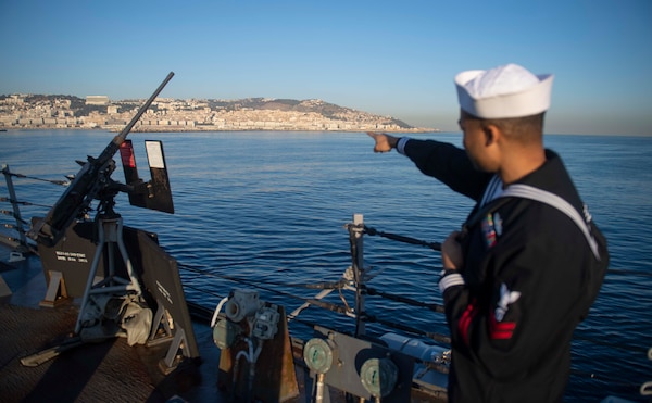 201018-N-KY668-1116 MEDITERRANEAN SEA (Oct. 18, 2020) Gas Turbine Systems Technician (Mechanical) 2nd Class Alva Johnson points to the skyline from the missile deck aboard Arleigh Burke-class guided-missile destroyer USS Roosevelt (DDG 80) as the ship pulls into Algiers, Algeria for a scheduled brief stop for fuel, Oct. 18, 2020. Roosevelt, forward-deployed to Rota, Spain, is on its first patrol in the U.S. Sixth Fleet area of operations in support of regional allies and partners and U.S. national security interests in Europe and Africa. (U.S. Navy photo by Mass Communication Specialist Seaman Austin G. Collins/Released)