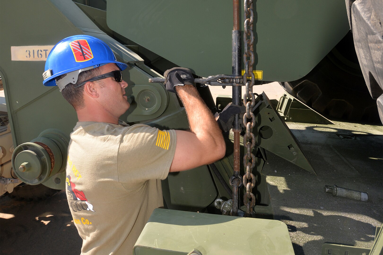 North Carolina National Guard Sgt. 1st Class Derek Winfree, a truck driver assigned to the 1452nd Combat Heavy Equipment Transporter Transportation Company, adjusts a chain hitch helping move heavy equipment from training sites across Fort Bragg, North Carolina, Oct. 15, 2020, in support of the 82nd Airborne Division.